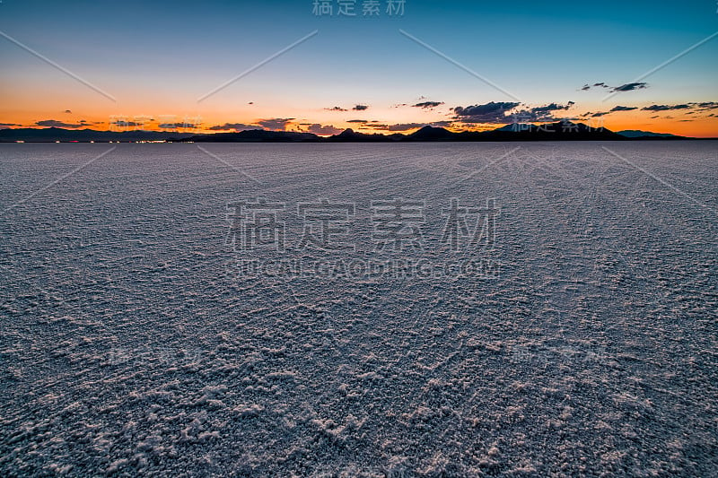 博纳维尔盐滩景观黑暗黄昏日落附近盐湖城，犹他州和剪影的山和汽车公路上