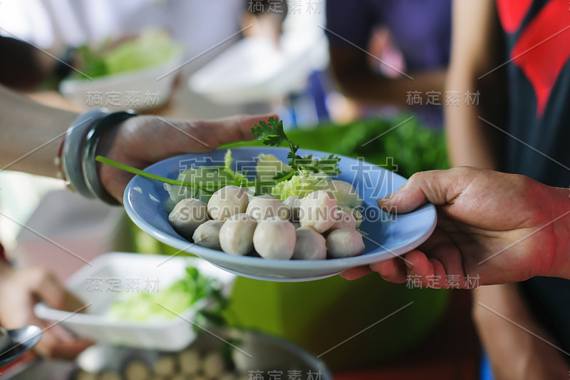 穷人接受捐赠的食物:无家可归的人得到食物救济，饥荒救济:志愿者给急需食物的穷人