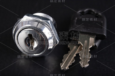 金属柜的小锁和钥匙。用于保护私人财产的附件。黑暗的背景。