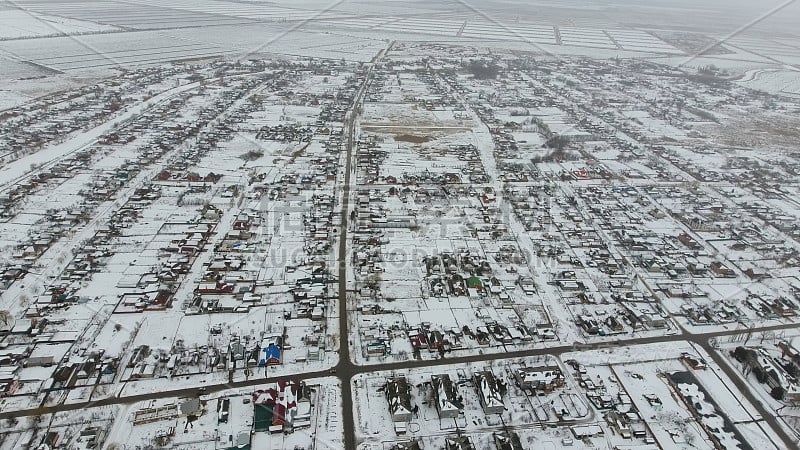 一个冬季村庄的顶视图。农村居民点被雪覆盖着。雪和冬天在村子里