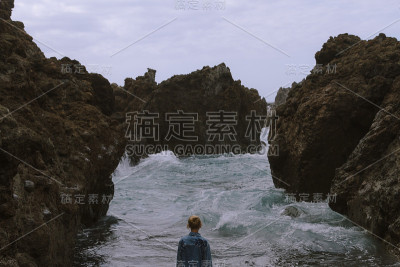 女孩站在沙滩上玩海浪在阴天