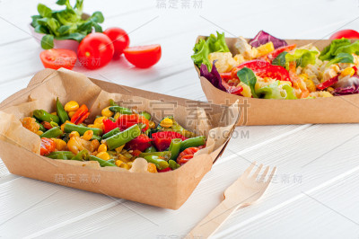 蔬菜沙拉在棕色的牛皮纸食品容器在木制背景