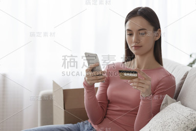 女性在智能手机上核实信用卡账户余额