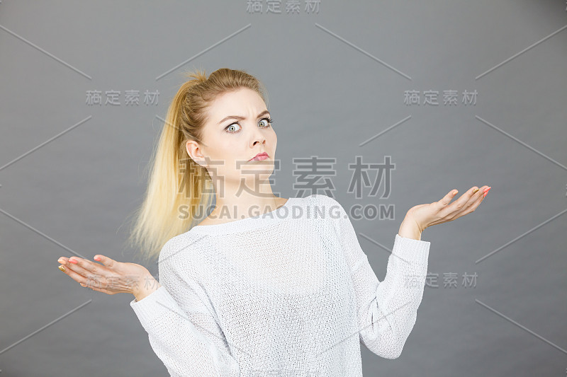 困惑的年轻金发女人用手打手势