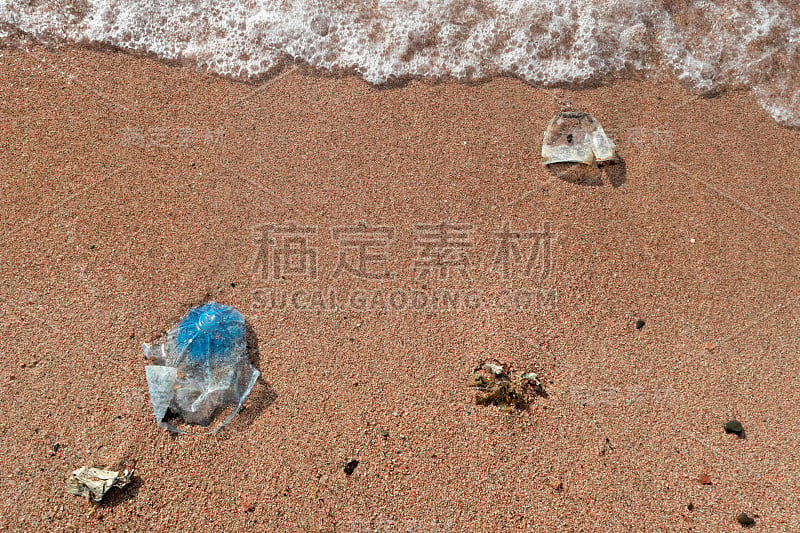 红海红色湿沙上的塑料垃圾