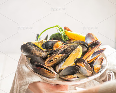 煮熟的贻贝用柠檬放在盘子里