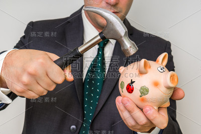 绝望的商人用锤子打碎了存钱罐