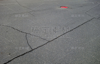 沥青裂缝和红色井盖。