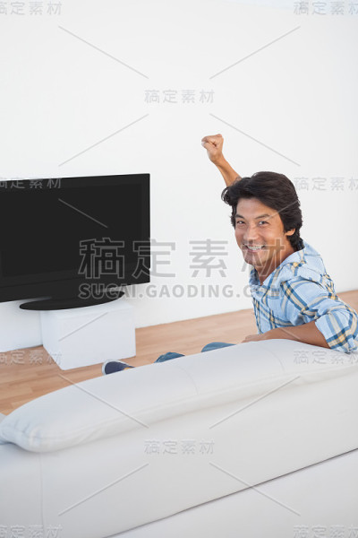 足球迷一边看电视一边欢呼