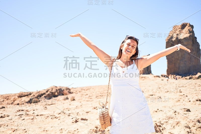 年轻美丽的女人享受暑假在山的景观，快乐地微笑在罗克努布洛山顶在大加那利亚