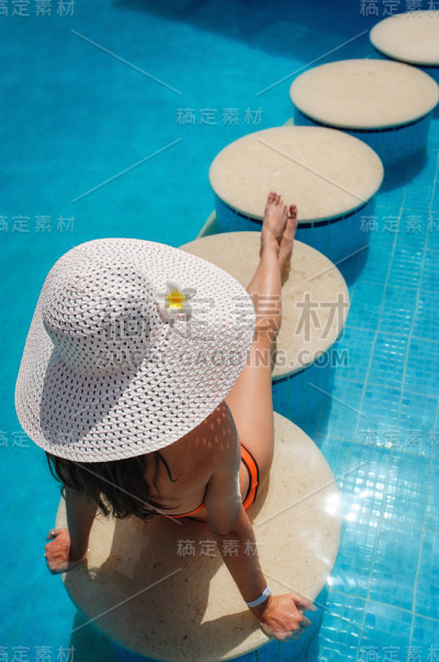 美丽的年轻女子在游泳池里放松