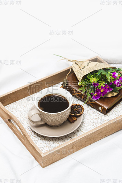 早上的新鲜咖啡，床单上放着包好的鲜花
