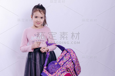 灰色背景下，手持书包的女学生