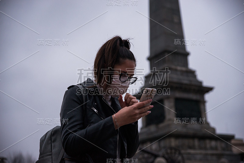 戴着面具的女人黄昏时分在街上打电话