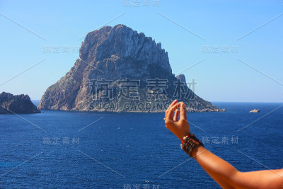 白种女孩放松做佛教冥想在悬崖前的Es Vedra岛在西班牙的海边在夏天Cala dhort