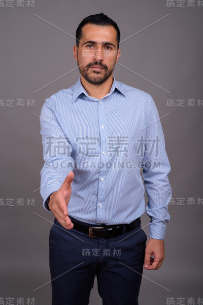灰色背景下的波斯商人的照片