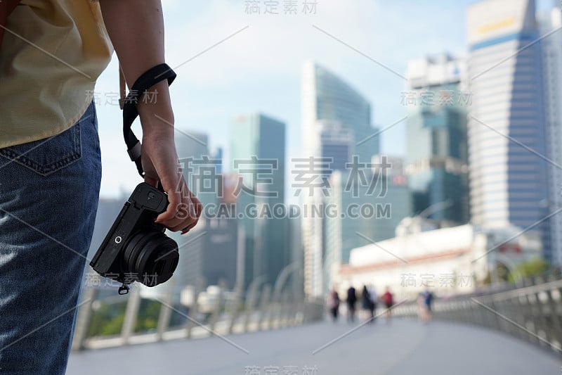 特写手拿相机的女子旅行者背包和帽子旅行进入新加坡市中心。新加坡旅游的概念。