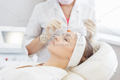 美容师在皮肤上涂上恢复青春的精华液