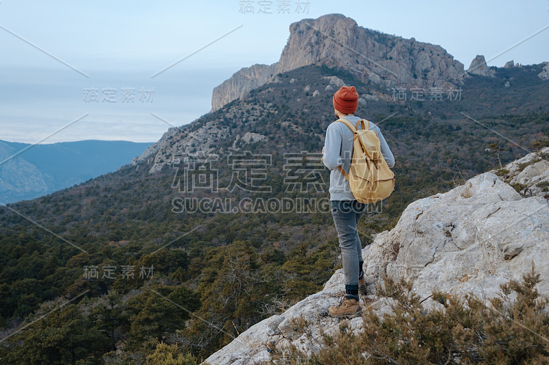 男人背包徒步旅行和红帽子在山区