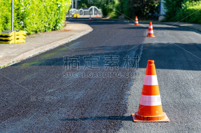 建筑锥体用一层新沥青标记部分道路。