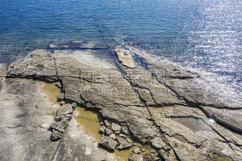 这是海滩的鸟瞰图，平坦的岩石悬崖浸没在海里