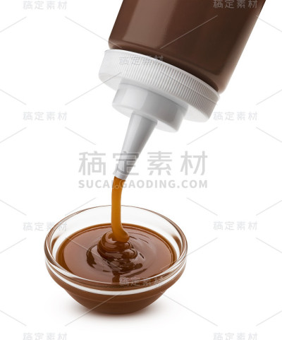 倒焦糖酱与瓶孤立的白色背景