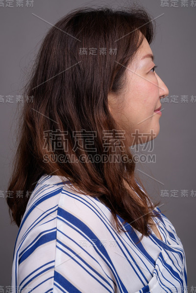 工作室拍摄的成熟美丽的亚洲女商人在灰色的背景