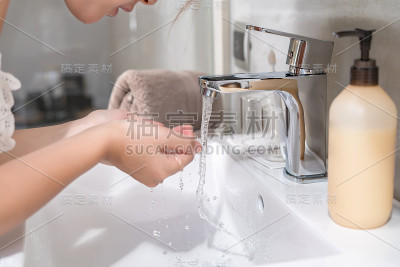 美丽的亚洲女人正在洗脸