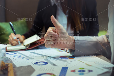 一个商人在会议上竖起大拇指。