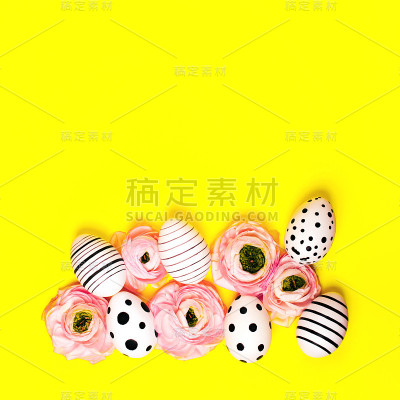创意的鸡蛋和毛茛花在明亮的黄色背景。