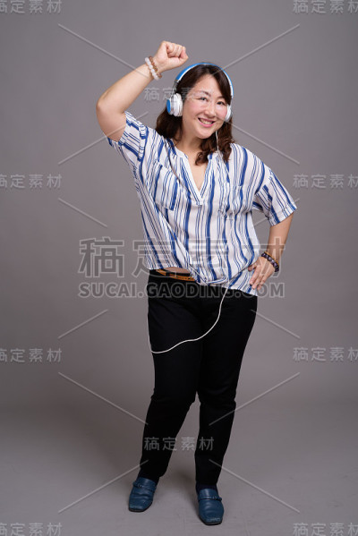 工作室拍摄的成熟美丽的亚洲女商人在灰色的背景