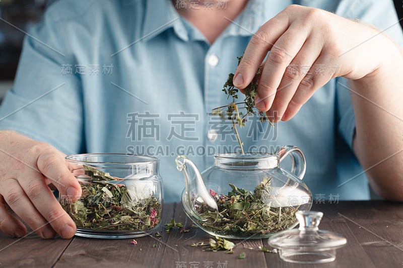 男手将花草茶放入水壶