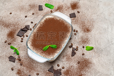 传统的意大利提拉米苏甜点在玻璃烤盘在混凝土背景