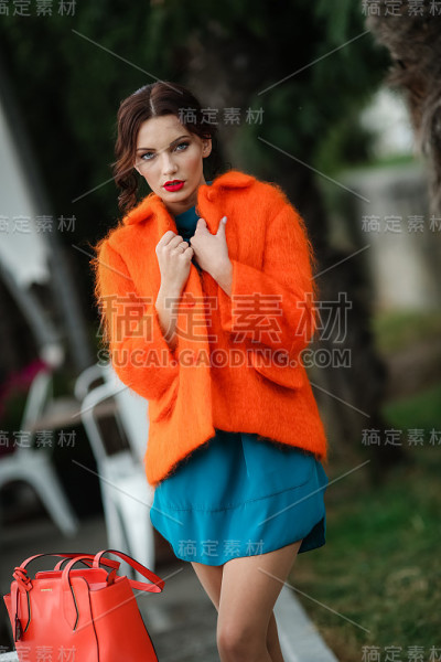 有魅力的年轻女子，带着一个红色的包，留着漂亮的发型