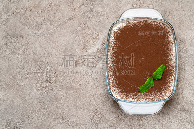 传统的意大利提拉米苏甜点在玻璃烤盘在混凝土背景