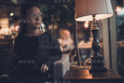 年轻女子透过窗户看。