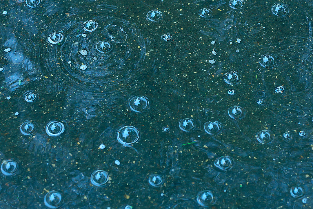 蓝色背景的雨水/雨滴,blue background puddle of rain / raindrops, circles on a puddle, bubbles in the water, the weather is autumn